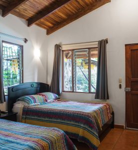 Guest room with comfortable beds and natural light at Villas Macondo in Tamarindo Costa Rica