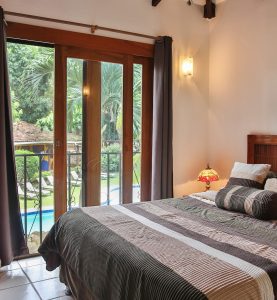Guest bedroom with balcony overlooking the pool at Villas Macondo in Tamarindo Costa Rica