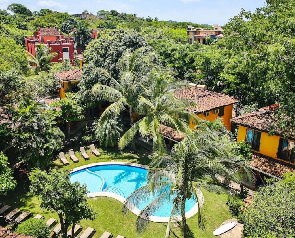 Tropical pool and courtyard surrounded by palm trees at Villas Macondo in Tamarindo Costa Rica