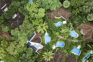 Aerial view of Cala Luna Boutique Hotel & Villas surrounded by tropical forest and resort pools in Tamarindo, Costa Rica.
