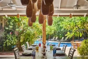 Poolside dining area surrounded by tropical gardens at Cala Luna Boutique Hotel in Costa Rica.
