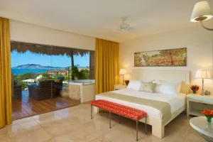 Luxury bedroom suite with ocean views, private terrace, and jacuzzi at a Costa Rica wellness retreat.