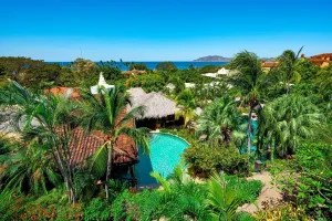 Tropical resort gardens with swimming pool and ocean views at a luxury wellness retreat in Costa Rica.