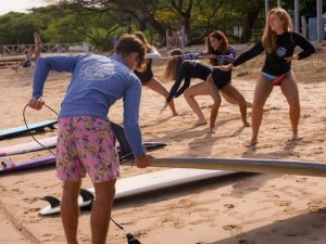 Surf instructor teaching beginner surfers beach training techniques before a surf lesson in Tamarindo, Costa Rica.