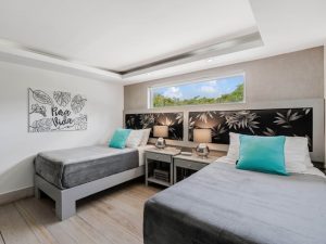 Clean and modern twin bedroom accommodation at a Costa Rica surf camp featuring comfortable beds and tropical decor.