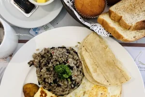 Traditional Costa Rican breakfast with rice, beans, eggs, tortillas, and fresh baked goods.